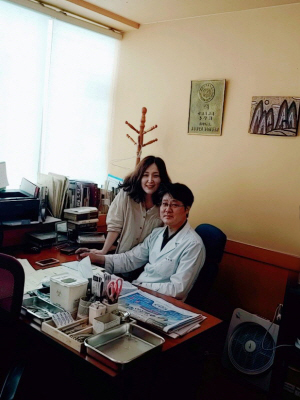 With her husband, an elder Gwang-suck Hong at the clinic.