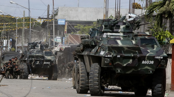 Government soldiers take cover beside armoured vehicles during a firefight with Muslim rebels from the MNLF in Zamboanga city, in southern Philippines
