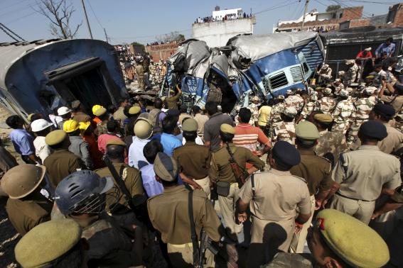 Indian security personnel and rescuers clear the debris of a passenger train after it derailed at Rae Bareli district in Uttar Pradesh